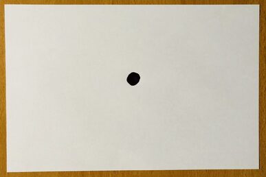 Zettel mit schwarzem Punkt